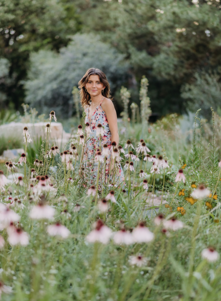 a senior is photographed standing in a field of flowers